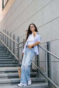 Young,Woman,In,A,Blue,Shirt,And,Jeans,Stands,On